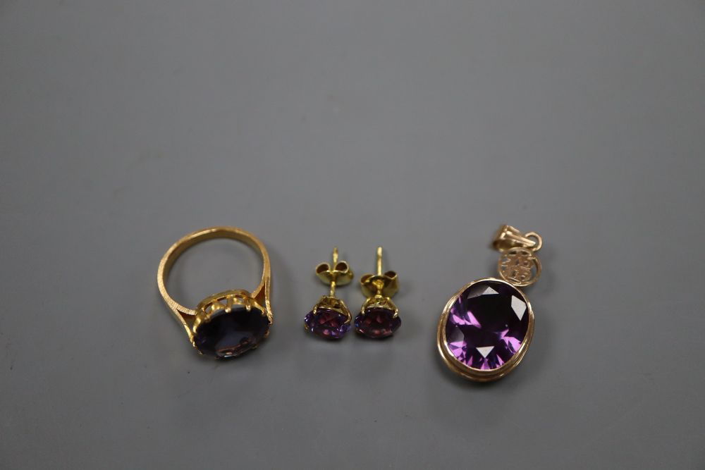 A 14k and synthetic colour change corundum pendant, a pair of similar earrings and a similar yellow metal dress ring, size M